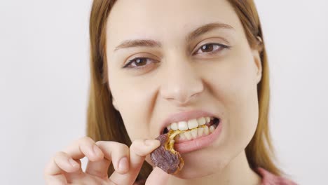 Woman-eating-fresh-dates-in-close-up.-Dry-fruits.